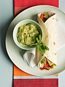 Fajitas filled with vegetables and served with guacamole