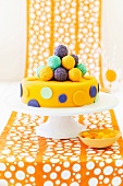 Spotted fondant-iced cake with cake balls for a children's party