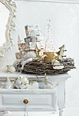 Stacked presents in willow wreath on shabby-chic table and Christmas baubles in open drawer