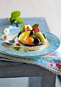 A fruit tartlet with mint leaves