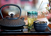 A tea-themed still life featuring a black teapot