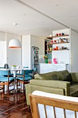 View from living area to dining area with tulip table and colourful ornaments on floating shelves