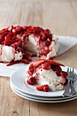 Strawberry and raspberry pavlova, with one slice served on a plate