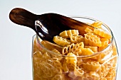 Dried pasta in a storage jar with a scoop