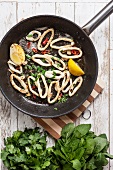 Fried squid rings with lemon, chilli and herbs