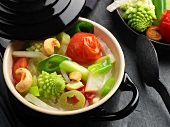 Delicate vegetable ragout in a black mini casserole pot