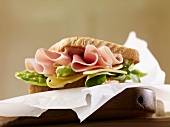 A sandwich filled with ham, cheese and lettuce