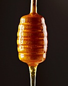 Honey flowing from a honey dipper (close-up)