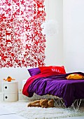 Curtain with red pattern of flowers and animals and bold purple bed linen