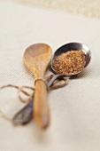Wooden and Silver Spoon Tied Together; Raw Sugar in the Silver Spoon