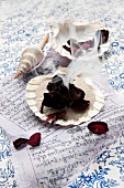 Incense - burning rose petals on sand, seashells on a Tibetan prayer flag as decoration