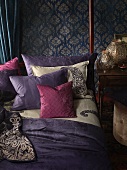 Bedroom in the Bohemian Look: bed with decorative pillows in front of a wall with patterned wallpaper