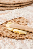Rye crispbread from Sweden with butter and a wooden knife