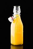 A bottle of orange juice with bits of pulp