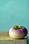 A turnip on a wooden board against a blue background