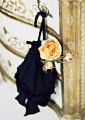Pompadour bag and apricot rose hung on chest of drawers