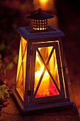 Lantern with candle illuminating a garden path