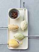 Four types of ice cream on spoons with grated chocolate