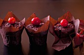 Chocolate and pear muffins garnished with whole cherry