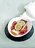 Salmon fillet with tomato salad and lemons