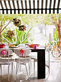 Flower arrangements suspended over festively decorated table and chairs