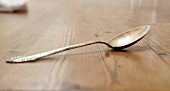 A silver spoon on a wooden table