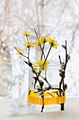 Arrangement in einem Glas: Blüten der Kornelkirsche und Weidenkätzchen, Weidenkätzchen mit Masking Tape am Glas gehalten