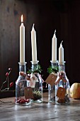 Candles and plant materials in bottles with numbered tags