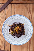 Chocolate fettuccine with almonds, pistachios, raisins and orange zest