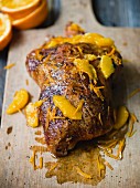 Duck with orange on a wooden board