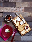 A cheeseboard with crackers and jam