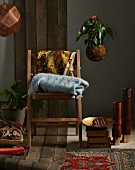 Shopping-Trends für den Winter: Holzstuhl mit Wolldecken, Bodenkissen, Teppiche und Lampe