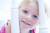 Little girl peeping through banisters