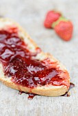 Freshly made strawberry jam on a slice of white bread