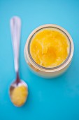 Lemon curd in a jar and on a spoon