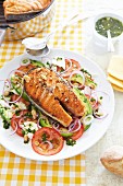Grilled salmon steak on a tomato and avocado salad