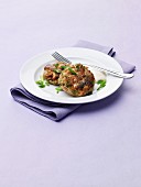 Two Salmon Cakes on a White Plate with Scallions