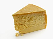 A wedge of parmesan on a white surface