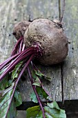 A beetroot with leaves on a rustic wooden table