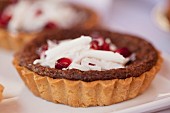 Individual chocolate tortes with grated chocolate and pomegranate seeds