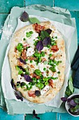 A pizza with herbs, peas and fava beans