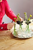 Close up of young woman arranging fresh flowers and plants