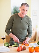 Man chopping vegetables in a kitchen