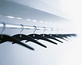 Coat hangers hanging from clothes rack