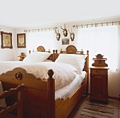 Farmhouse bedroom with ornate carved furniture and hunting trophies