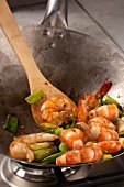 Glazed prawns with spring onions in a wok