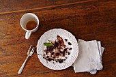 The Remains of Chocolate Cake on a White Plate with a Finished Cup of Tea