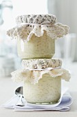 Jars of rice pudding topped with crocheted doilies for presents