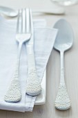 Cutlery with lace trim decorating handles on table