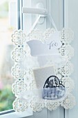 Hand-crafted note rack made from crocheted doilies and lace ribbon hanging on door handle